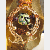Mixed metal sterling and copper wire woven lampwork organic swirling pendant